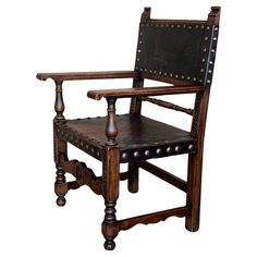 an old wooden chair with leather upholstered on the back and armrests