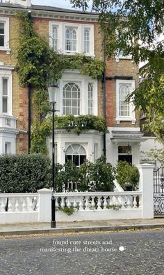 a white house with ivy growing on it's windows and balconies in front