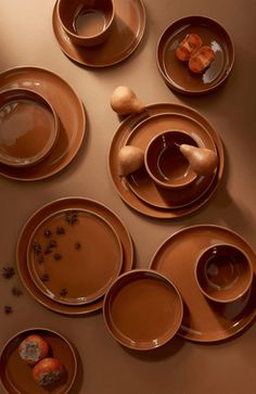 a table topped with lots of brown plates and bowls