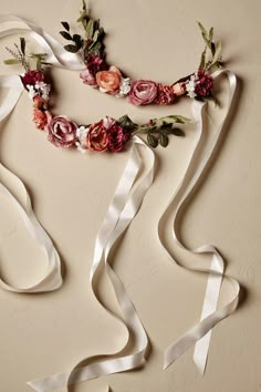 two ribbons with flowers on them are tied to the wall and ready to be used as headpieces