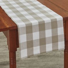 a wooden table topped with a white and gray checkered table cloth