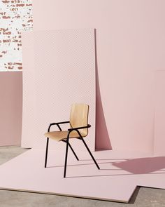 a wooden chair sitting on top of a pink floor next to a white and brown wall