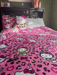 a hello kitty bed spread with pink sheets and pillow cases on top of the bedspread