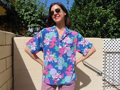 "This rad take on a Hawaiian shirt is in comfortable cotton with an allover pattern of hibiscus flowers and fruit including sea green pineapples, lavender pears, mauve plums, and indeterminate red orbs. It has a button and loop collar, which is pretty cool.  Styled with 1980s Levi's available here: https://www.etsy.com/listing/1571285449/1980s-lavender-levis-jeans-550-relaxed   47\" chest  27.5\" length Modern size Large/XL Vintage size men's M per tag Sizes as listed on Etsy are my best guess P Vintage Hawaiian Shirts 50s, Vintage Multicolor Hawaiian Shirt, Pink Hawaiian Shirt, Hawaiian Button-up Shirt With Hibiscus Print For Vacation, Retro Printed Button-up Hawaiian Shirt, Blue Retro Hawaiian Button-up Shirt, Hibiscus Flowers, Levis Jeans, Hawaiian Shirt