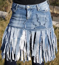 a woman is wearing a skirt made out of old jeans and has fringes on it