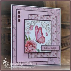 a close up of a greeting card with flowers and butterflies on the front, in pink