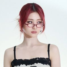 a woman with red hair and glasses is wearing a black and white tank top that has the letter b on it