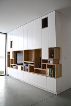 a living room filled with lots of furniture and a flat screen tv mounted to the wall