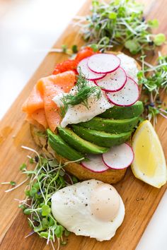 an open face sandwich with avocado, radishes and sliced cucumbers