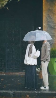 two people standing under an umbrella in the rain