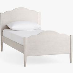 the bed is made up with white linens on it and has an arched headboard