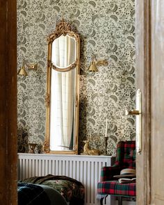 a chair sitting in front of a mirror next to a wall mounted radiator