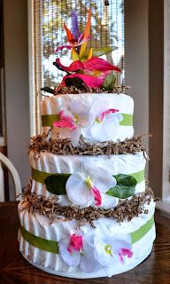 a three tiered cake with flowers on it sitting on top of a wooden table