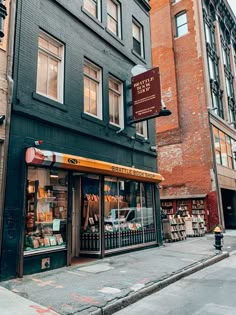 an empty street corner in front of a store with many books on the shelves and windows