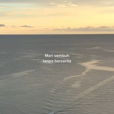 an airplane flying over the ocean at sunset with text that reads marti sembuh tampa berceria