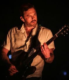 a man holding a guitar in his right hand