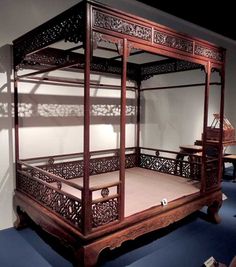 an antique wooden bed in a room with blue carpet