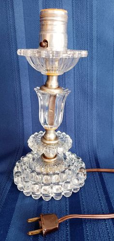 an old fashioned glass candle holder on a blue background