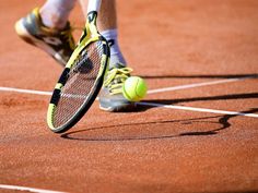 a tennis player is about to hit the ball with his racket on the court