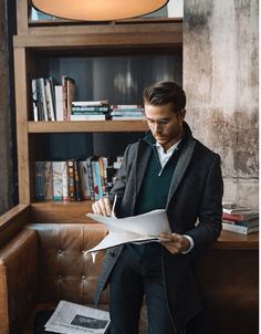 a man sitting on a couch reading a piece of paper