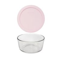 an empty glass bowl with a pink lid on a white background, next to a plastic plate