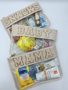 two zippered pouches filled with snacks and baby items on top of a white table