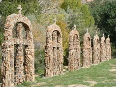 several stone sculptures are lined up in the grass