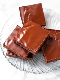 four pieces of chocolate cake on a glass plate