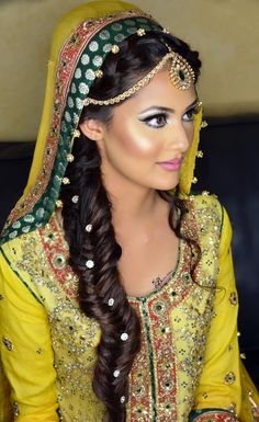 a woman with long hair wearing a yellow and green wedding dress is posing for the camera