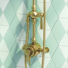 a gold faucet on the side of a wall with blue and white tiles