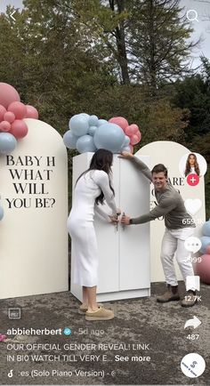 a man and woman standing next to each other in front of two giant balloons with the words baby i, what will you be?