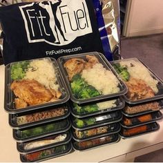 six plastic containers filled with food on top of a white table next to a black bag