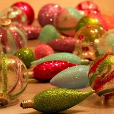 a bunch of christmas ornaments sitting on the floor next to each other, all covered in glitter