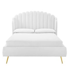 a bed with white sheets and pillows on top of it's headrests