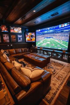 a living room with two couches and a large screen tv on the wall in front of it