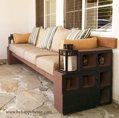 a couch sitting on top of a stone floor next to a window