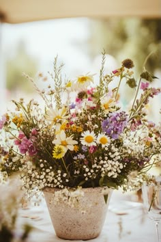 a vase filled with lots of flowers sitting on top of a table