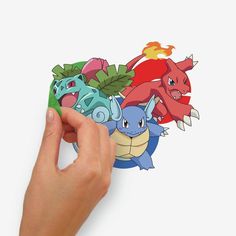 someone is holding up a sticker with different pokemons on it