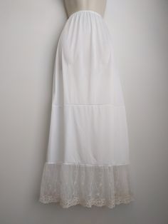 "An exquisite accessory for your wardrobe, this feminine underskirt slip worn with your skirt or dress will make you feel very special! It is made of white nylon with elastic waistband and 7 inches embroidered very soft ivory lace ruffle trim. This accessory makes a perfect gift! Hand wash in cold water. Available in sizes: XS-0-2, Waist: 24 1/2\", Hip: 35\" S-4-6, Waist: 25 1/2\"-26 1/2\", Hip: 36-37\" M-8-10, Waist: 27 1/2-28 1/2\", Hip: 38-39\" L-12-14, Waist: 30-31 1/2\", Hip: 40 1/2-42\" XL White Delicate Lace Skirt For Summer, White Fitted Daywear Skirt, White Fitted Skirt For Daywear, Fitted Summer Skirt With Delicate Lace, Fitted Delicate Lace Skirt For Summer, Fitted White Skirt With Floral Embroidery, Summer Fitted Skirt With Delicate Lace, White Fitted Skirt With Floral Embroidery, White Floral Embroidery Skirt For Wedding