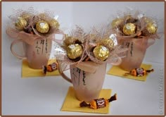 three mugs filled with chocolate candies on top of yellow napkins