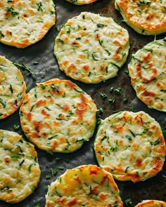 small pizzas with cheese and herbs on a baking sheet, ready to be eaten