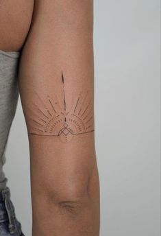 a woman's arm with a tattoo on it and the sun in the background