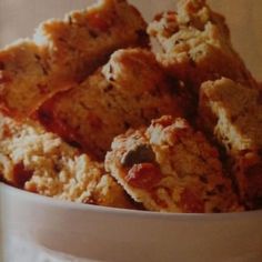 a white bowl filled with oatmeal and raisins bars sitting on top of a table