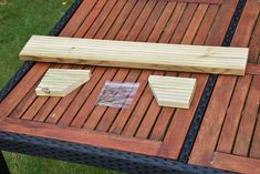 some pieces of wood sitting on top of a wooden table with nails and tape around them