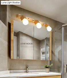 a bathroom with a sink, mirror and light fixture in it's center area