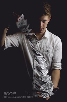 a man is holding up some cards in his hands