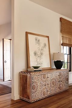 a large wooden cabinet sitting on top of a hard wood floor next to a window