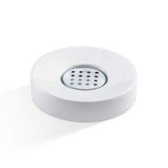 a white round object with holes in the center on a white surface, it appears to be part of an electronic device