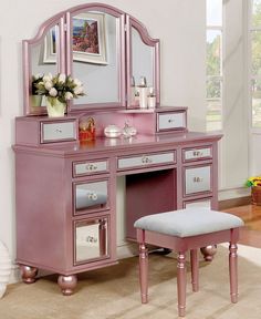 a pink vanity with mirror and stool in a room