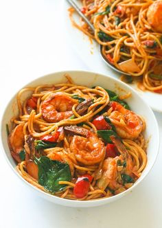 two white bowls filled with pasta and shrimp